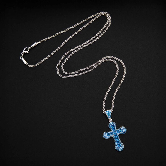 Silbern glänzende Kette mit blauem Kreuzanhänger auf schwarzem Hintergrund.