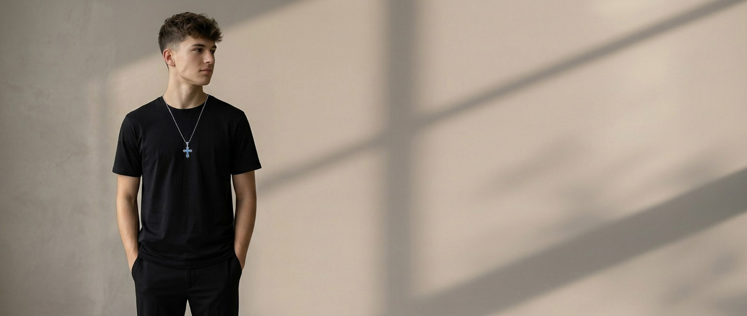 Bild eines jungen Mannes mit Kreuzkette und schwarzem T-Shirt.